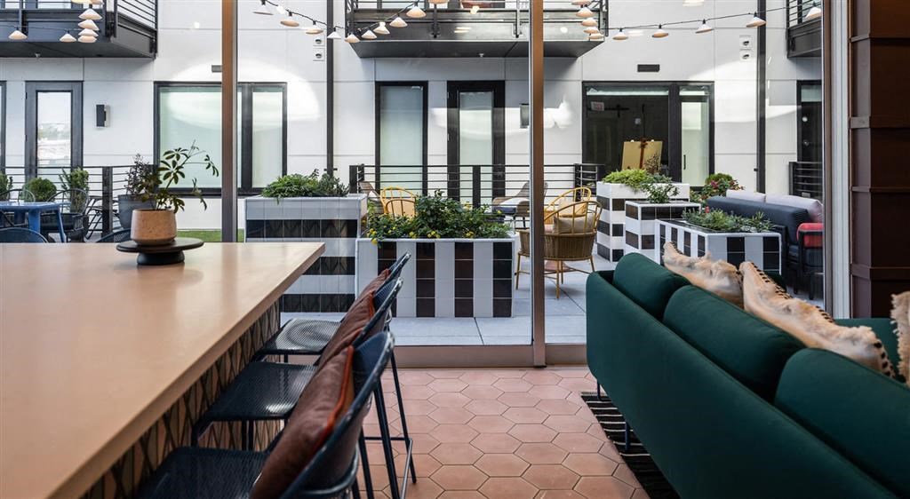 a room with a green couch and black chairs