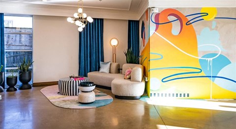 a living room with a couch and a colorful wall