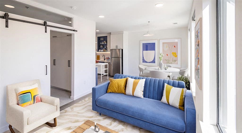 a living room with a blue couch and yellow and white pillows