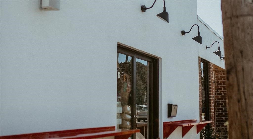 a white building with a glass door and a red fence
