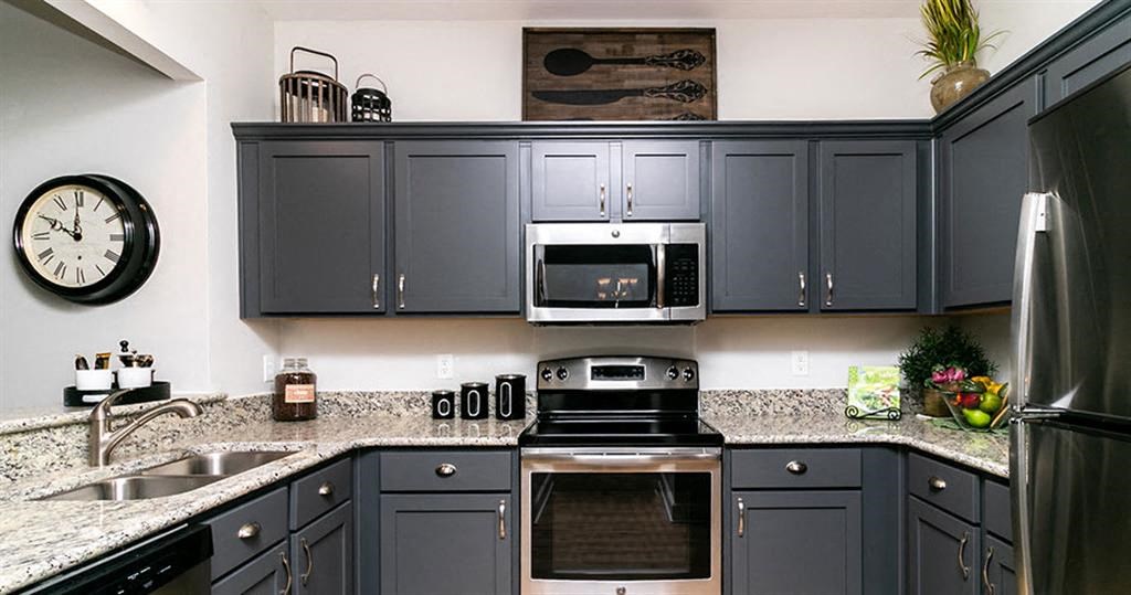 a kitchen with gray cabinets and granite counter tops  at Saltmeadow Bay, Virginia Beach