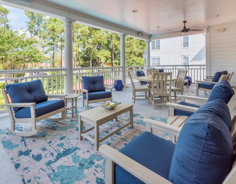 a porch with blue couches and chairs and a table at Sterling Manor, Williamsburg, 23185