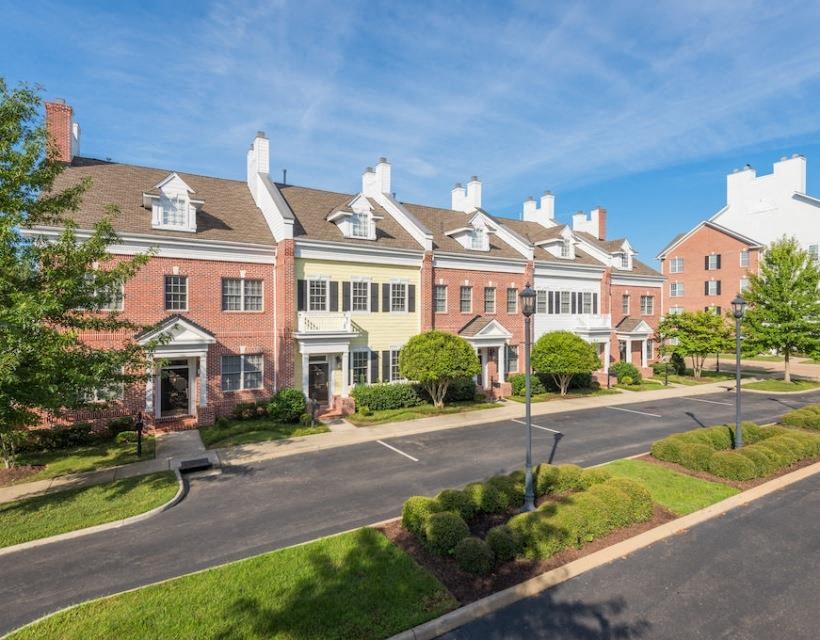 a row of houses on a street with a blue sky in the background at Sterling Manor, Williamsburg, VA