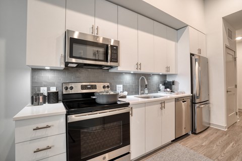 a kitchen with stainless steel appliances and white cabinets at Vista Brooklynn Apartments, Jacksonville, FL, 32202