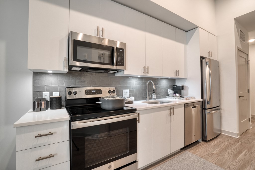 a kitchen with stainless steel appliances and white cabinets a kitchen with stainless steel appliances and white cabinets at Vista Brooklynn Apartments, Jacksonville, FL, 32202