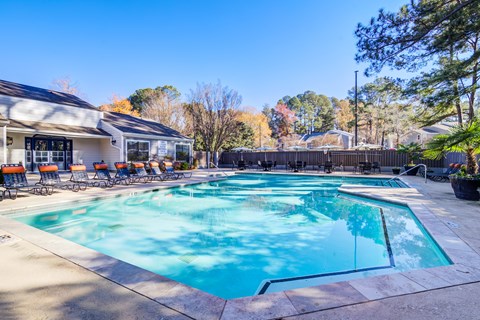 A large swimming pool with a slide and sun loungers.