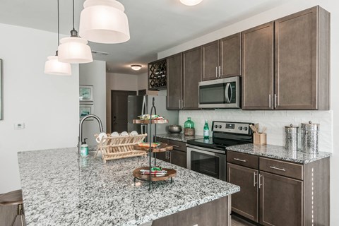 a kitchen with granite counter tops and wooden cabinets at Village at Westland Cove Apartments, Tennessee, 37922