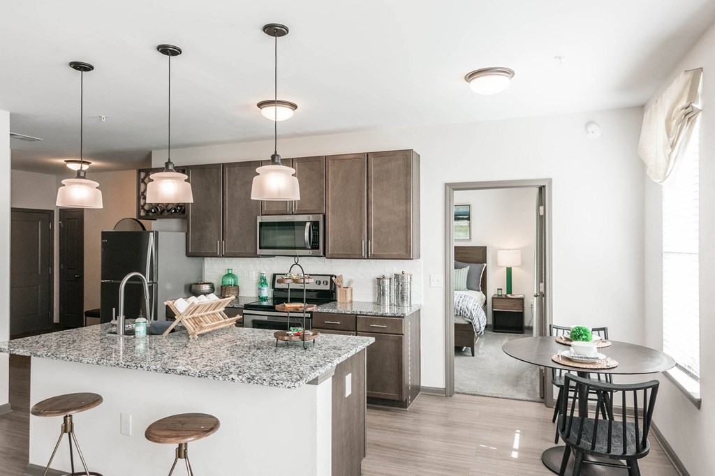 a kitchen and dining area with a marble counter top a kitchen and dining area with a marble counter top at Village at Westland Cove Apartments, Tennessee