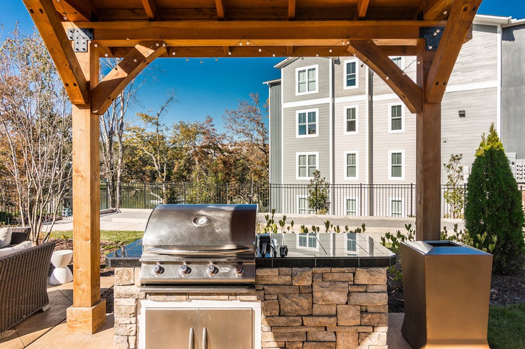 an outdoor kitchen with a grill and a wooden structure at Village at Westland Cove Apartments, Knoxville, TN, 37922