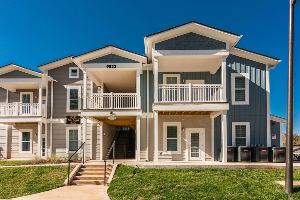 an apartment building with stairs and a sidewalk in front of it at Village at Westland Cove Apartments, Knoxville, TN