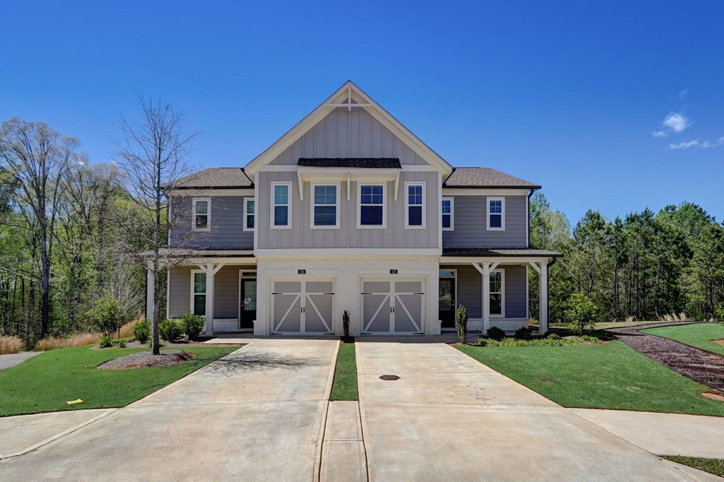 a blue house with white doors and a driveway