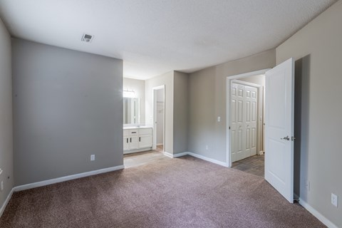 A room with a carpeted floor and a doorway leading to another room.