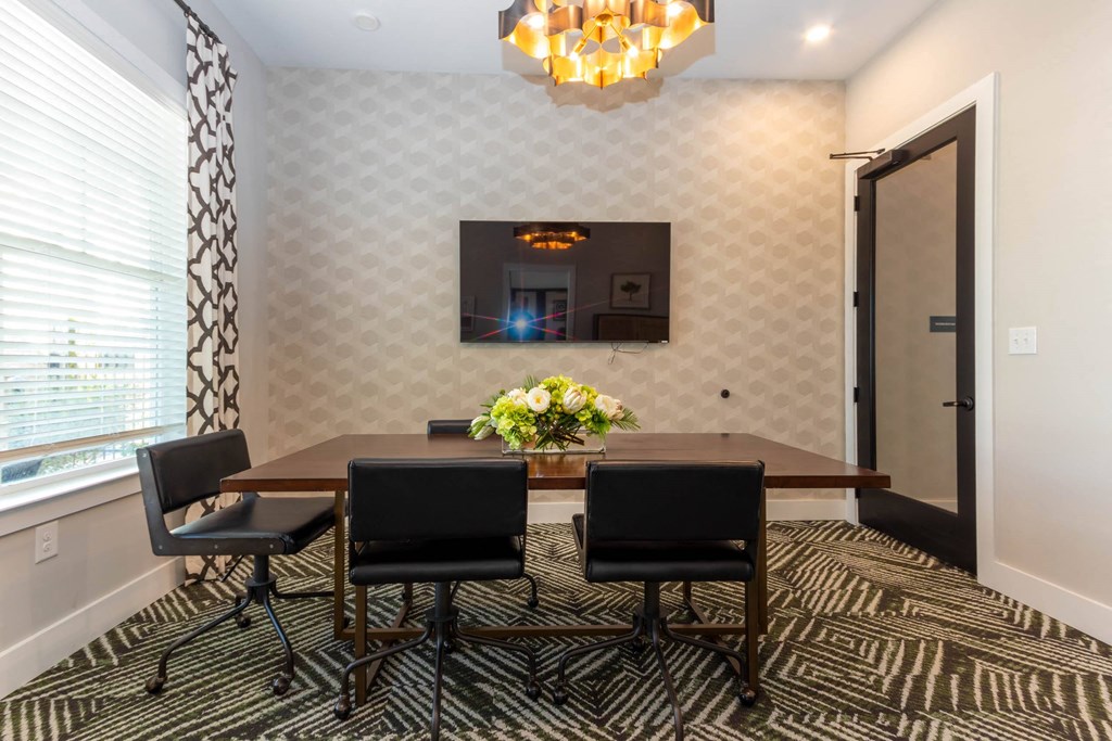 a dining room with a table and chairs and a tv on the wall at Capstone at Banks Crossing, Commerce