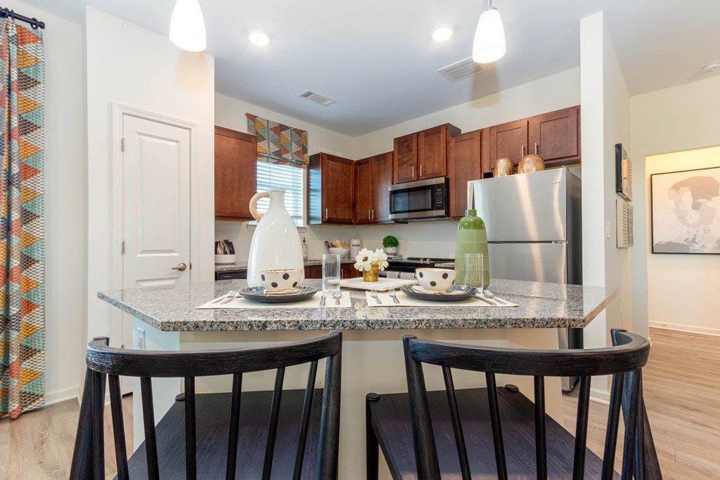 a kitchen with a counter top with two stools at Capstone at Banks Crossing, Commerce, GA
