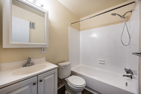 A white toilet sits next to a white sink in a bathroom.