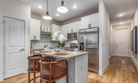 A kitchen with a table and chairs in front of a counter.