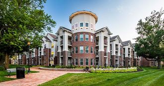 a large building with a round tower on top of it at Canopy at Ginter Park Apartments, Richmond, VA, 23227