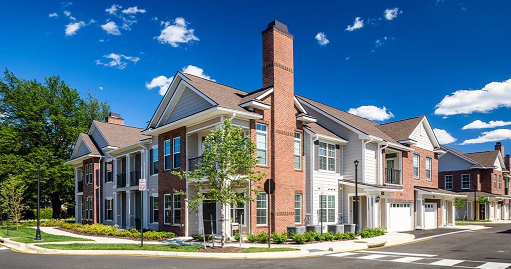 a street scene of a row of townhomes with a blue sky in the background at Canopy at Ginter Park Apartments, Richmond, VA, 23227