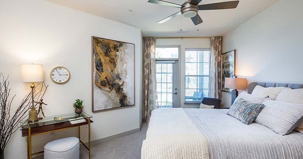 a bedroom with a bed and a ceiling fan