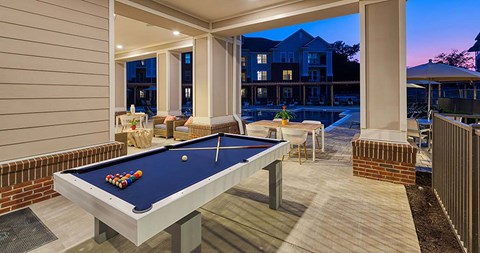 a pool table on a patio with a pool house in the background at Canopy at Ginter Park Apartments in Richmond, VA 23227