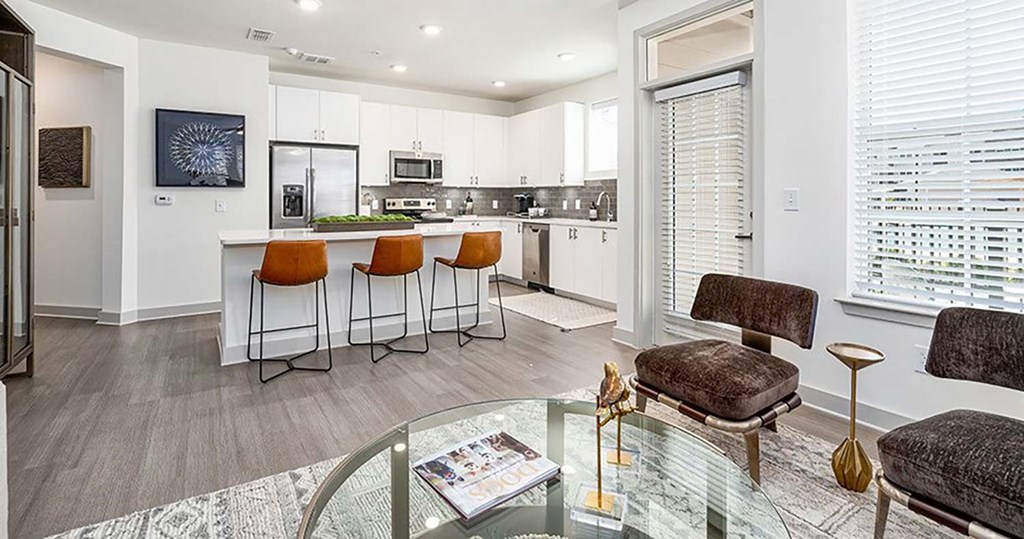 a kitchen and living room with a table and chairs