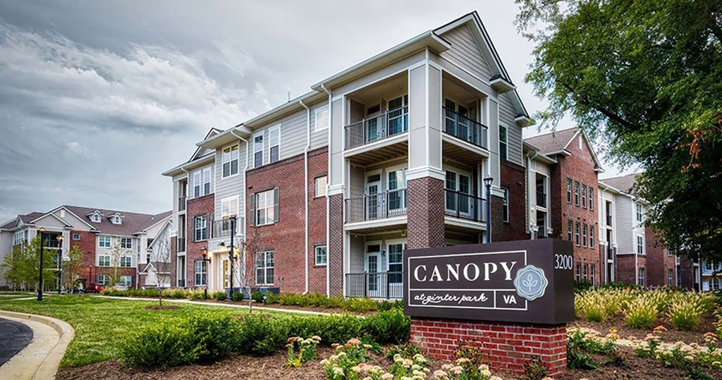 a large apartment complex with a sign in front of it