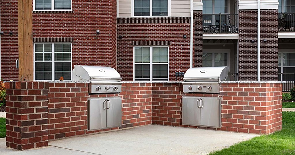a brick wall with two grills in front of a building