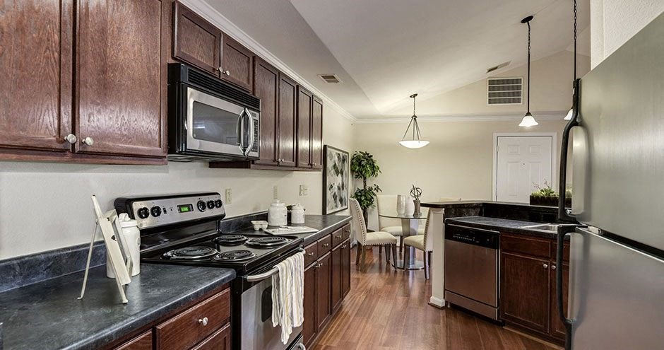a kitchen with a stove top oven next to a microwave at SomerHill Farms Apartments, Gainesville, VA
