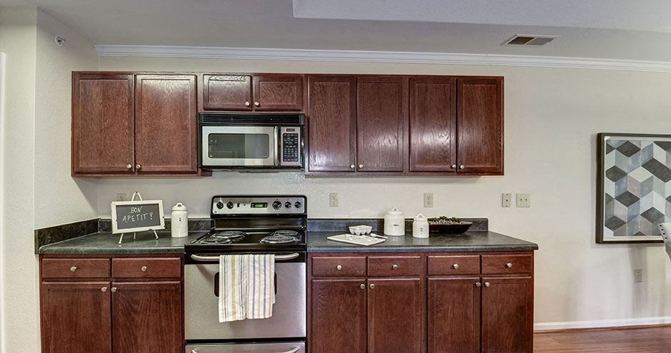 a kitchen with a stove and a microwave at SomerHill Farms Apartments, Gainesville, VA