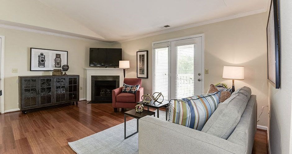 a living room with a couch a chair and a fireplace at SomerHill Farms Apartments, Gainesville, VA 20155