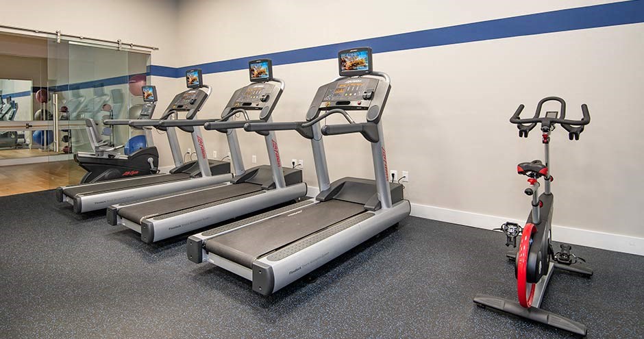 a row of treadmills and exercise bikes in a gym at Bellemeade Farms Apartments, Leesburg, VA