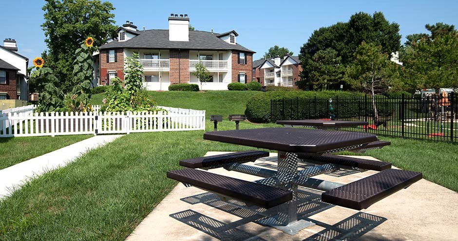 a picnic table in a park with a house in the background at Bellemeade Farms Apartments, Leesburg, 20175