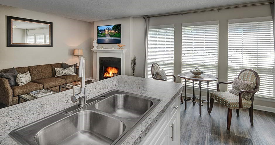 a kitchen with a sink sitting next to a fireplace at Bellemeade Farms Apartments, Leesburg Virginia