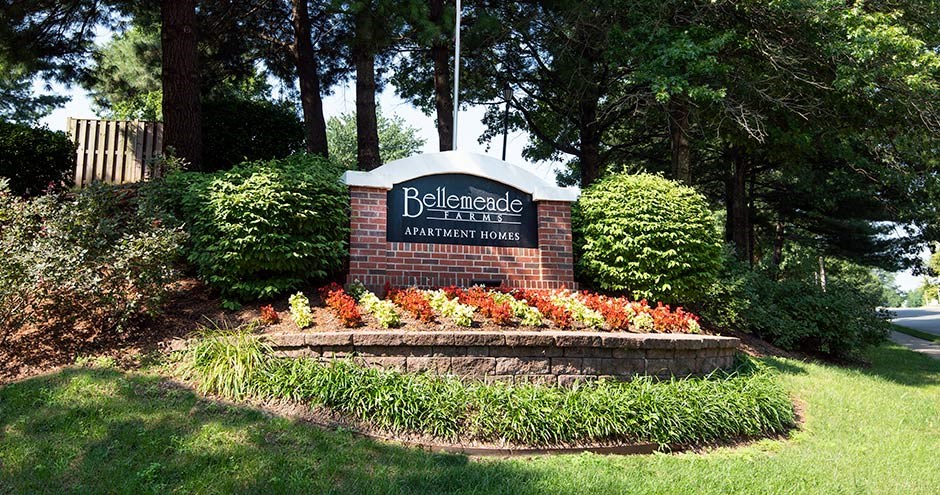 a brick sign with a black and white sign on top of it at Bellemeade Farms Apartments, Leesburg, VA