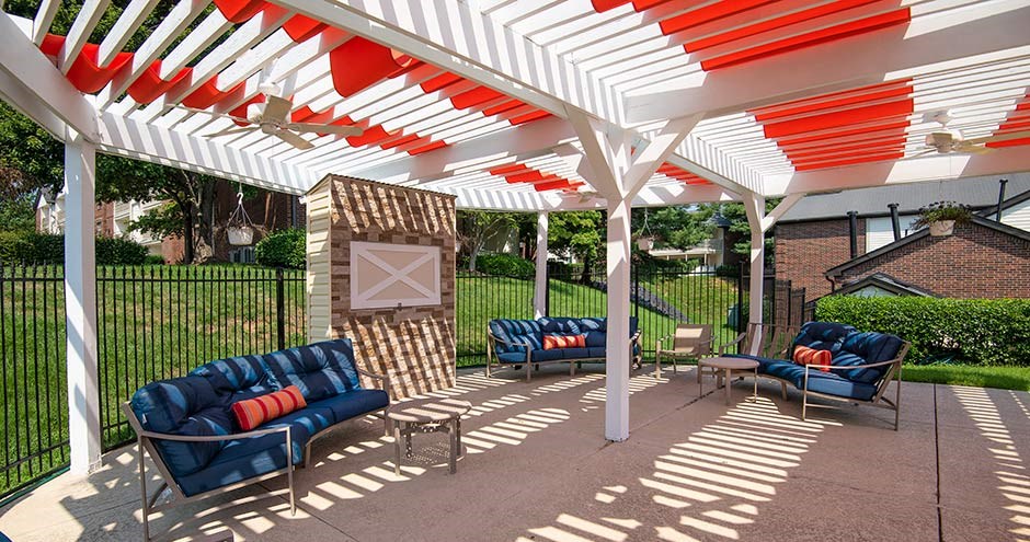 a white and red pergola with blue couches and chairs under it at Bellemeade Farms Apartments, Leesburg, VA 20175