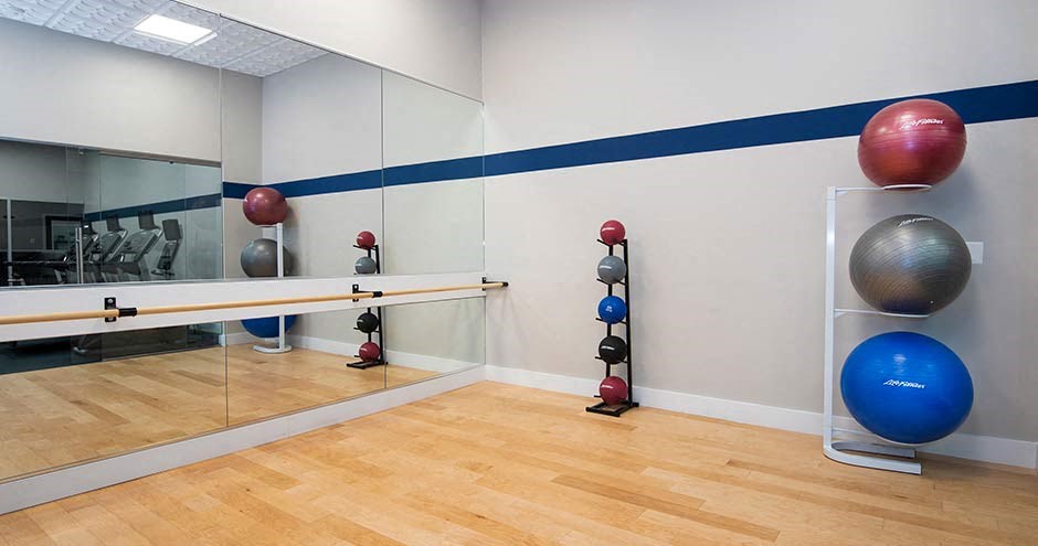 a yoga studio with a wood floor and a large mirror at Bellemeade Farms Apartments, Leesburg, 20175