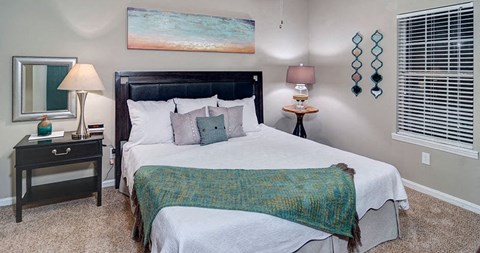 A bedroom with a large bed and a painting on the wall at Austin Chase Apartments, Georgia