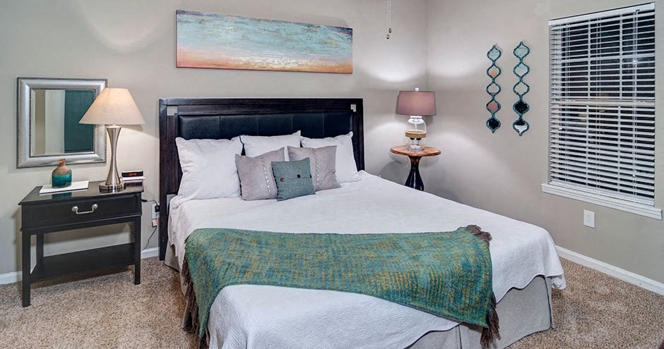 A bedroom with a large bed and a painting on the wall A bedroom with a large bed and a painting on the wall at Austin Chase Apartments, Georgia