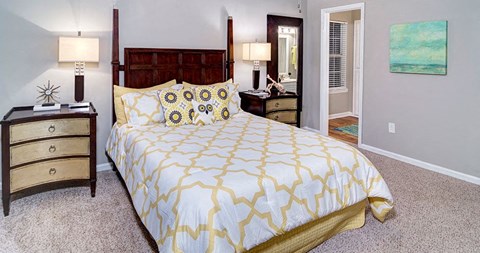 A bedroom with a bed, nightstand, and lamp at Austin Chase Apartments, Macon, 31210