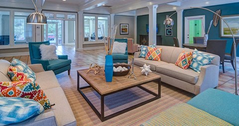 A living room with a sofa, armchair, and coffee table at Austin Chase Apartments, Macon, GA