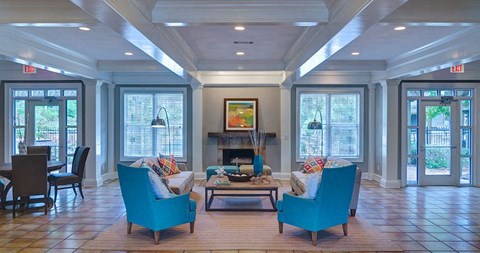 A living room with a fireplace and two chairs at Austin Chase Apartments, Georgia