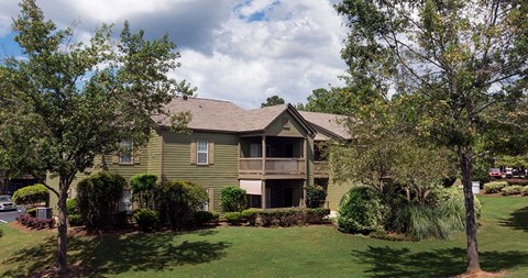 A green house with a brown roof and a balcony at Austin Chase Apartments, Macon, 31210