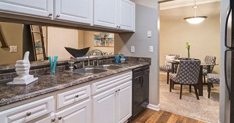 A kitchen with white cabinets and a black refrigerator at Austin Chase Apartments, Georgia 31210