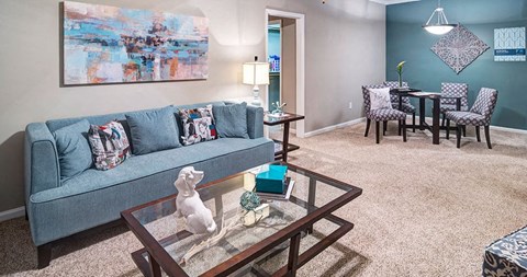 A living room with a grey couch and a glass coffee table at Austin Chase Apartments, Macon, 31210
