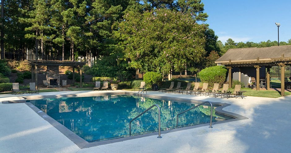A large outdoor swimming pool surrounded by trees A large outdoor swimming pool surrounded by trees at Austin Chase Apartments, Macon, Georgia