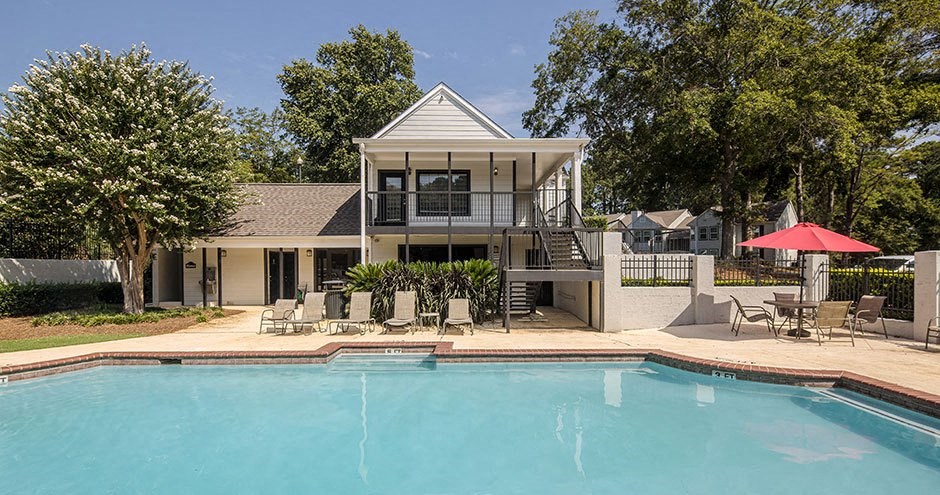 A house with a pool in front of it.