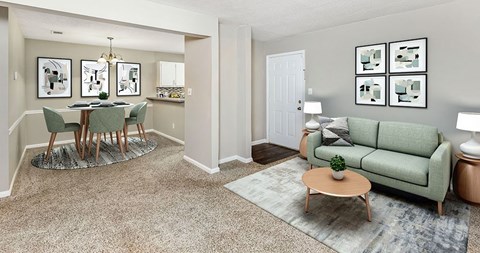 A living room with a green couch and a dining table with chairs.