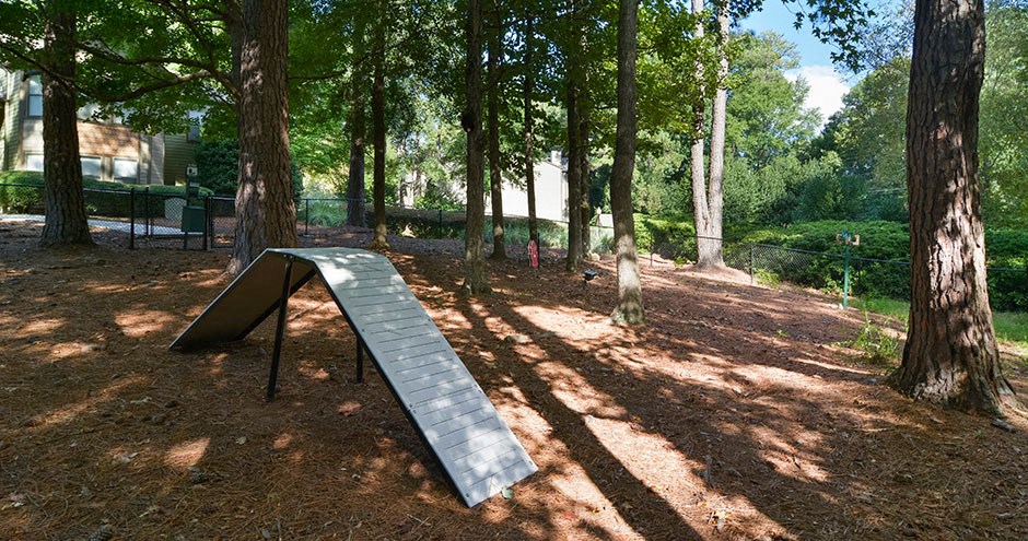 A playground slide in a park with trees in the background.