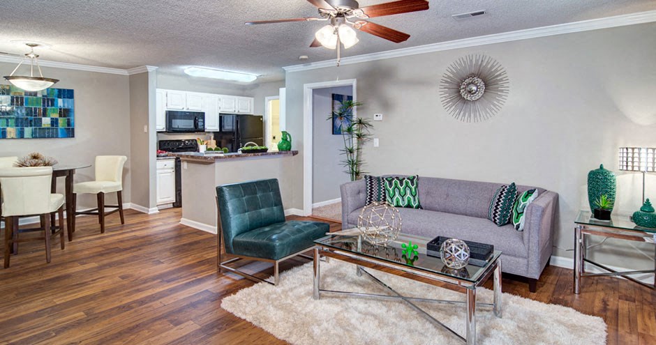 A living room with a grey couch and a glass coffee table at Huntington Chase Apartments, Warner Robins