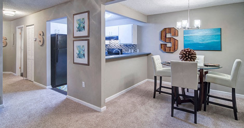 A dining room with a table set for four.